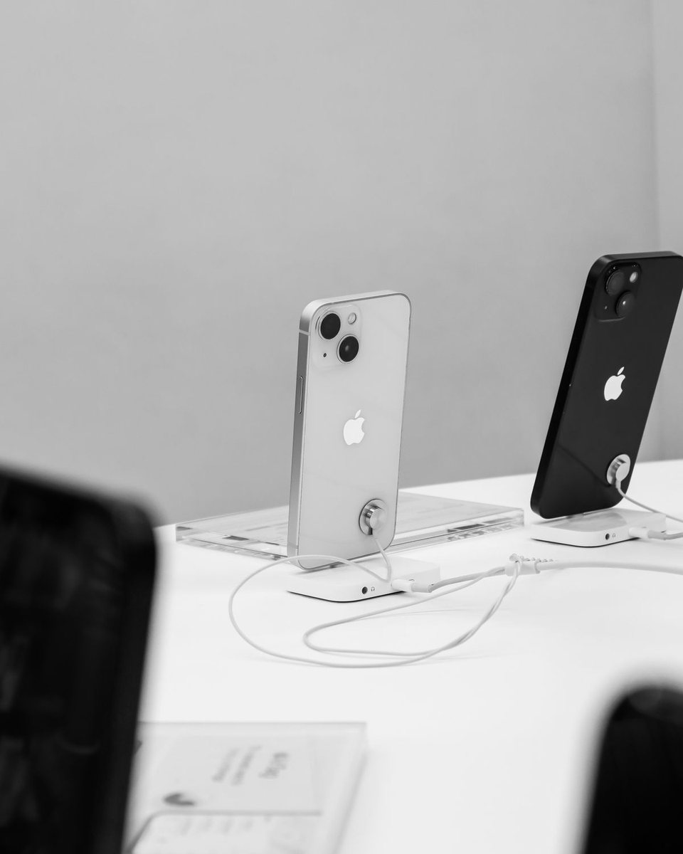Zwei Smartphones nebeneinander auf Ausstellungsständern auf einem hellen Ladentisch